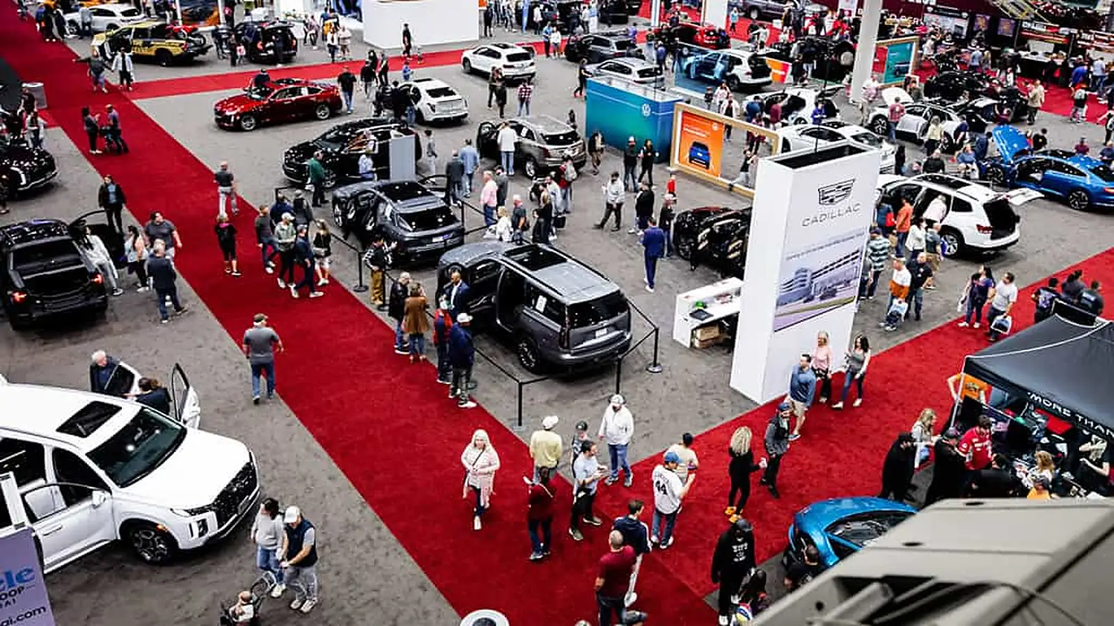 Visitors explore vehicle and boat exhibits on the Houston Auto Show floor.