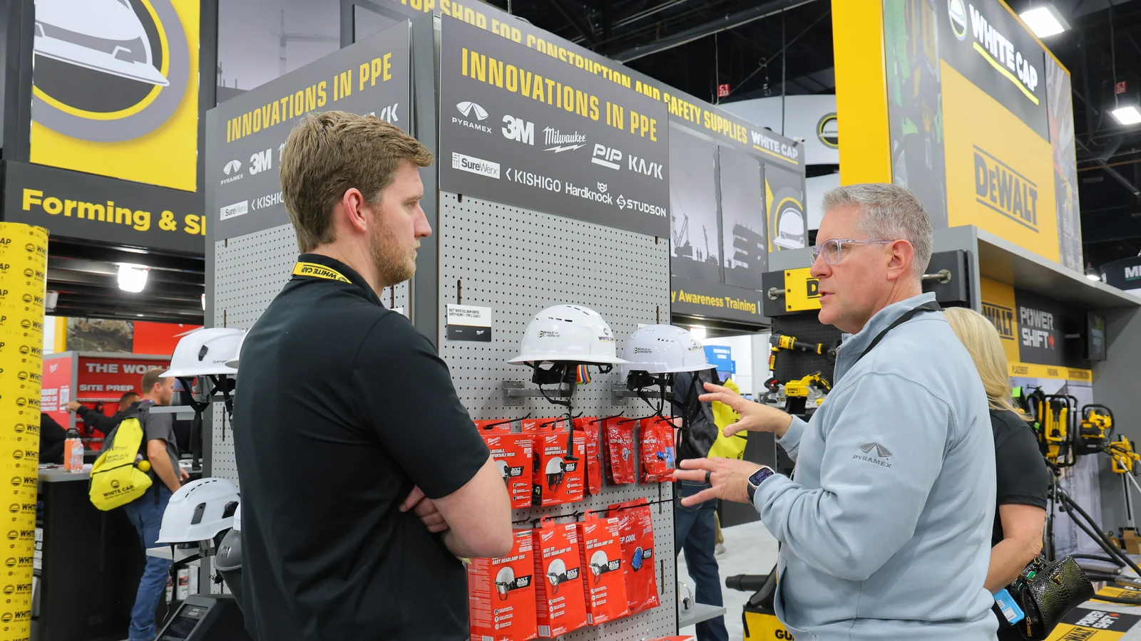 Attendees discuss construction safety products at a World of Concrete exhibit.