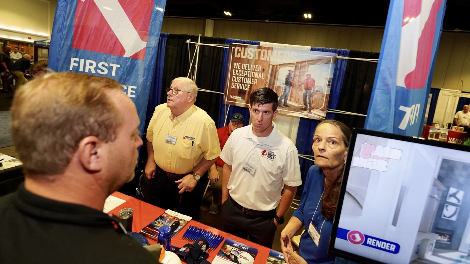 Attendees speak with exhibitors at a Build Expo USA booth.