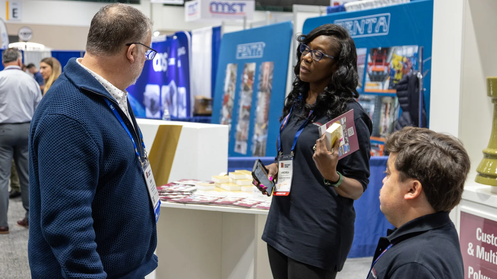 Attendees discuss precast products at an exhibitor booth during The Precast Show.