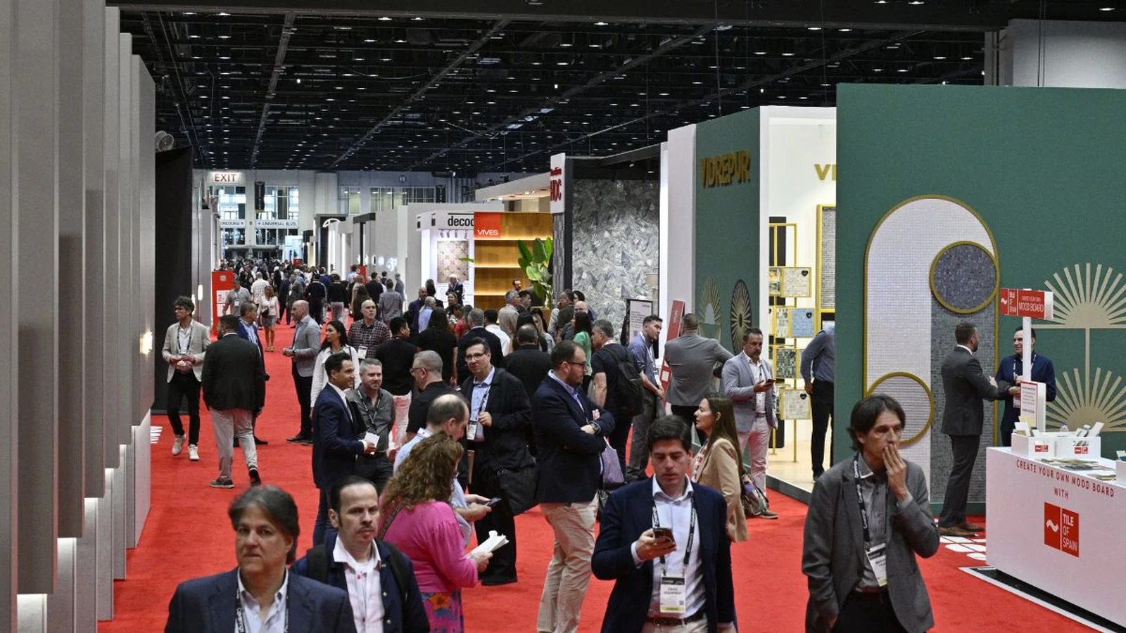 Coverings attendees walk a busy show floor lined with tile and stone exhibits.