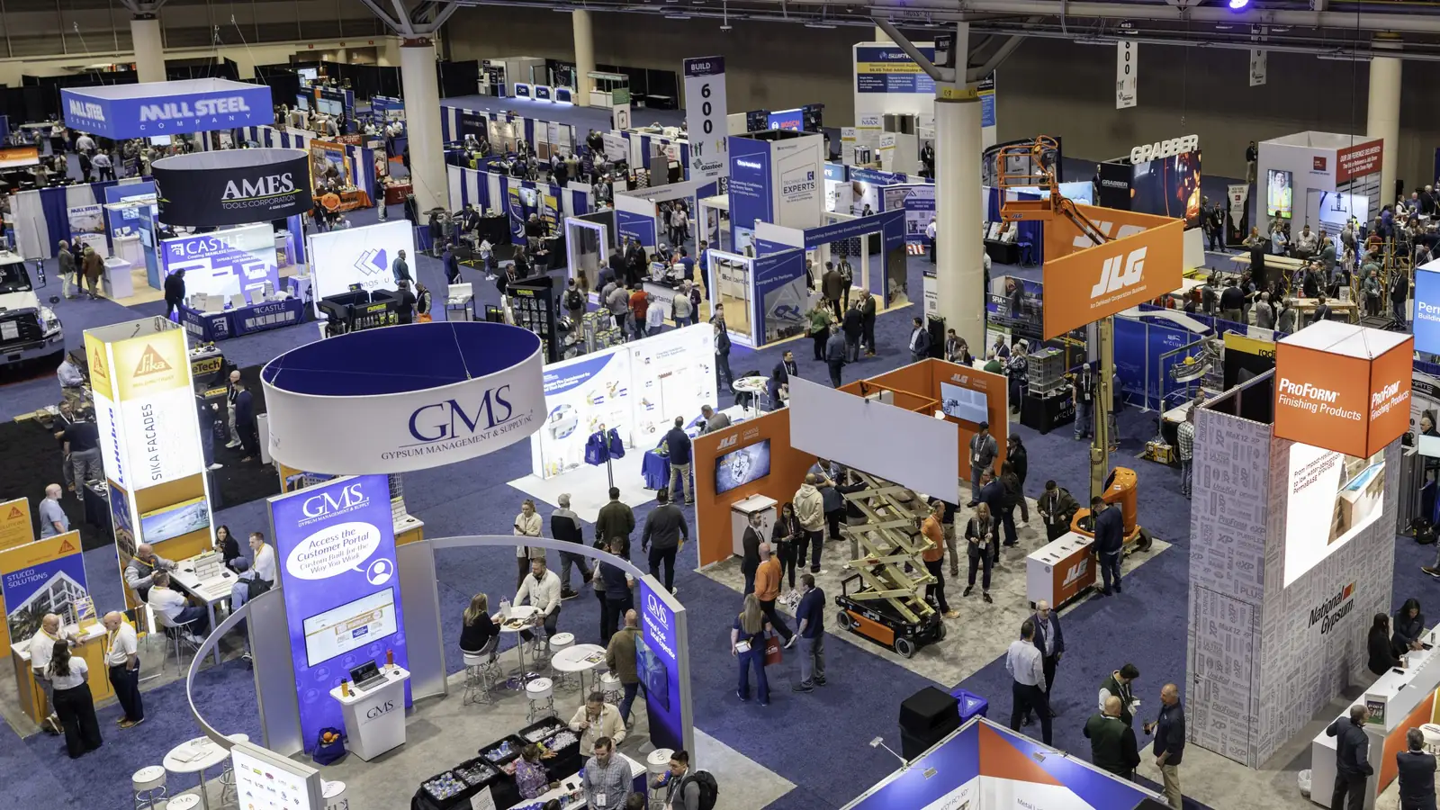 Aerial view of the AWCI BUILD expo floor with wall and ceiling industry booths and attendees.