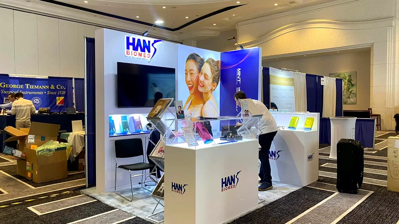Hans Biomed 10x10 booth with a screen, illuminated product counters and a compact staff position.