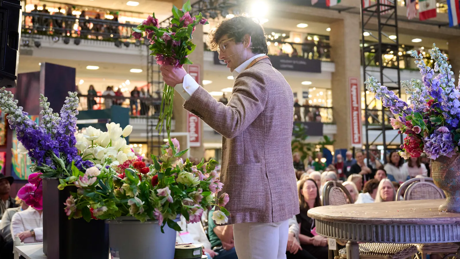 A Dallas Total Home & Gift Market exhibitor presents floral products to buyers.