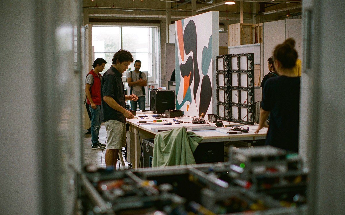 graphic production and AV preparation in one view - a printed wall panel on a work table with an LED video wall module a