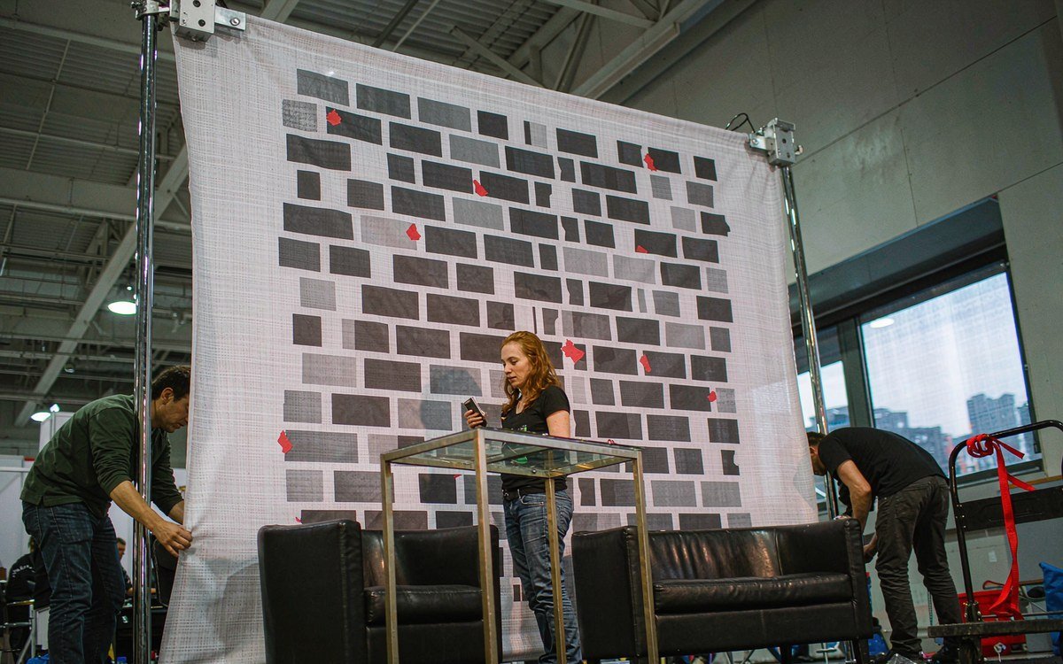 large printed fabric wall installed as a booth backdrop in a convention hall