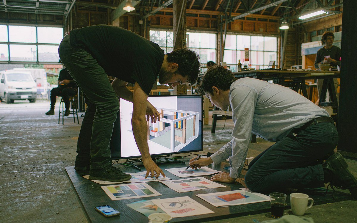 booth design review at a wide monitor in a studio