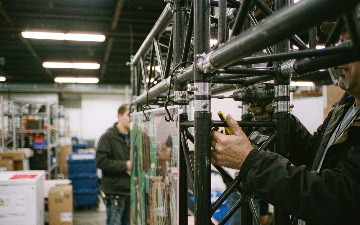 truss structure trial-assembled with a printed graphic panel and a monitor mounted together