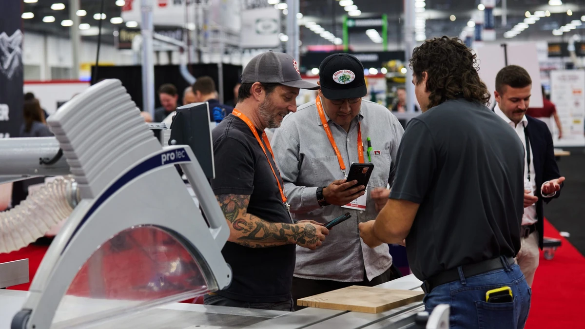Woodworking professionals reviewing machinery on a previous AWFS Fair show floor.