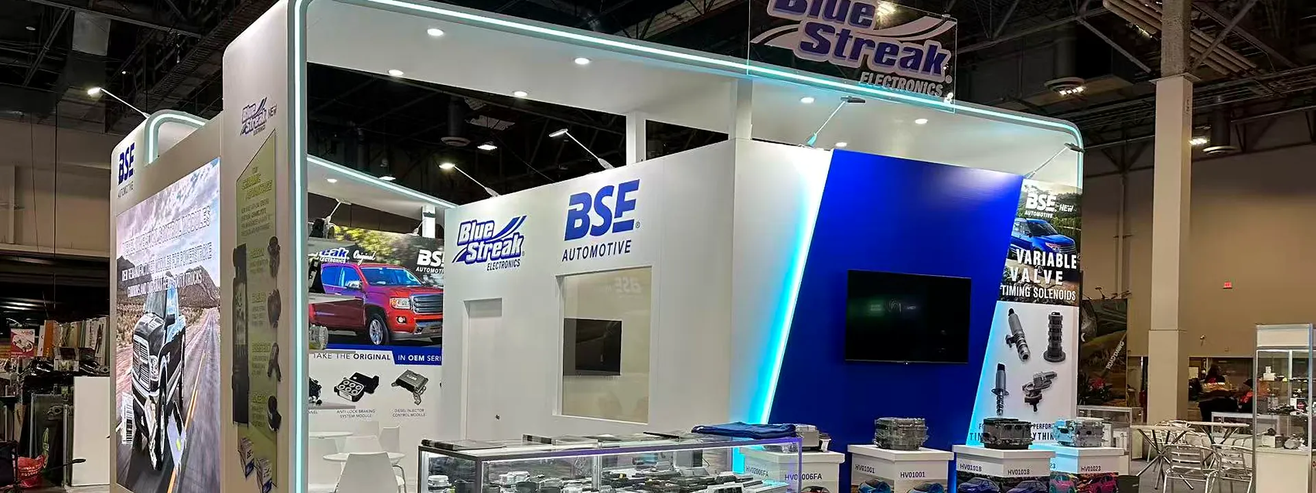 Blue Streak automotive exhibit with white counters, blue lighting, and product displays