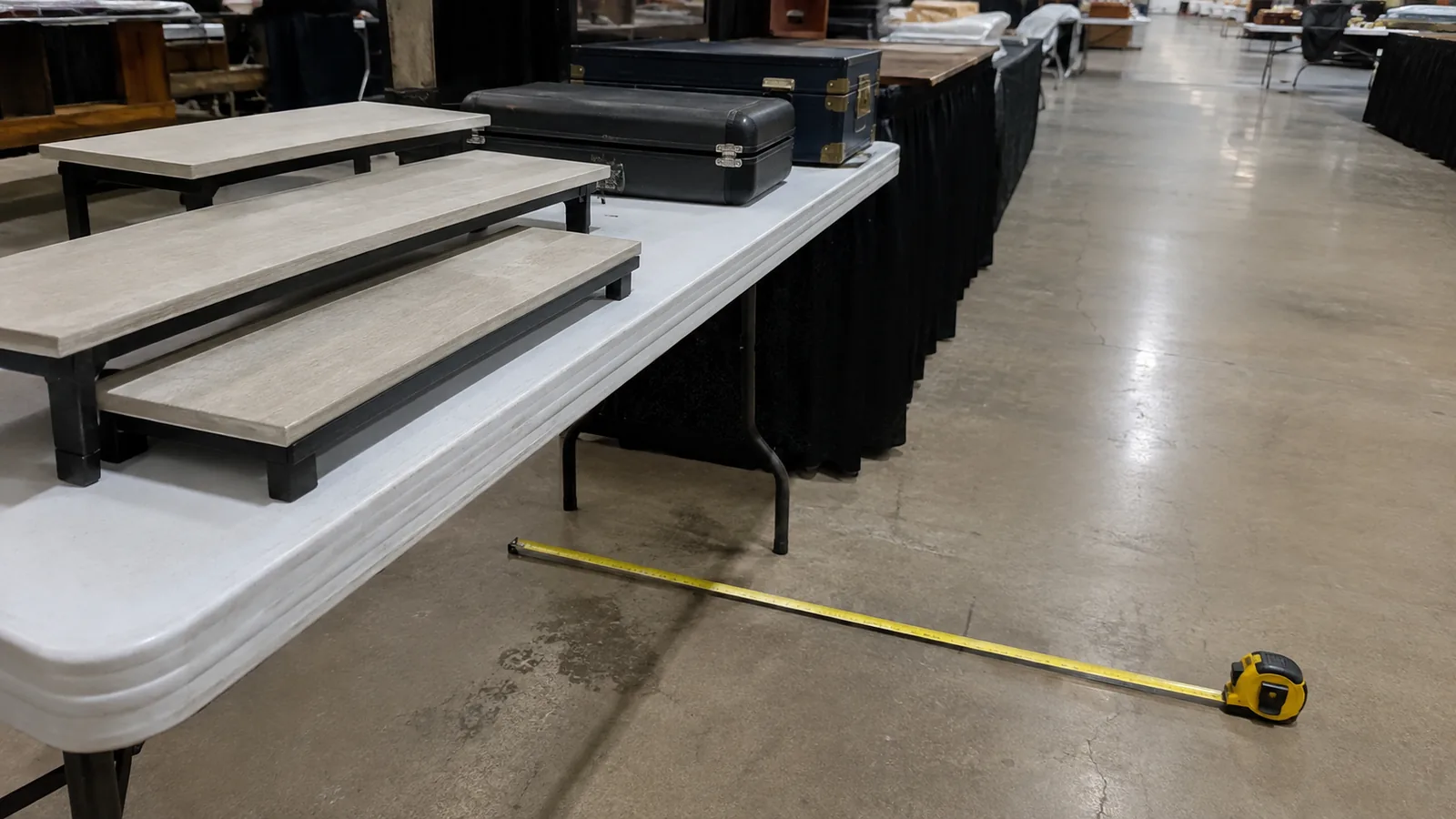 Low display risers and measured aisle clearance for a table-based public show