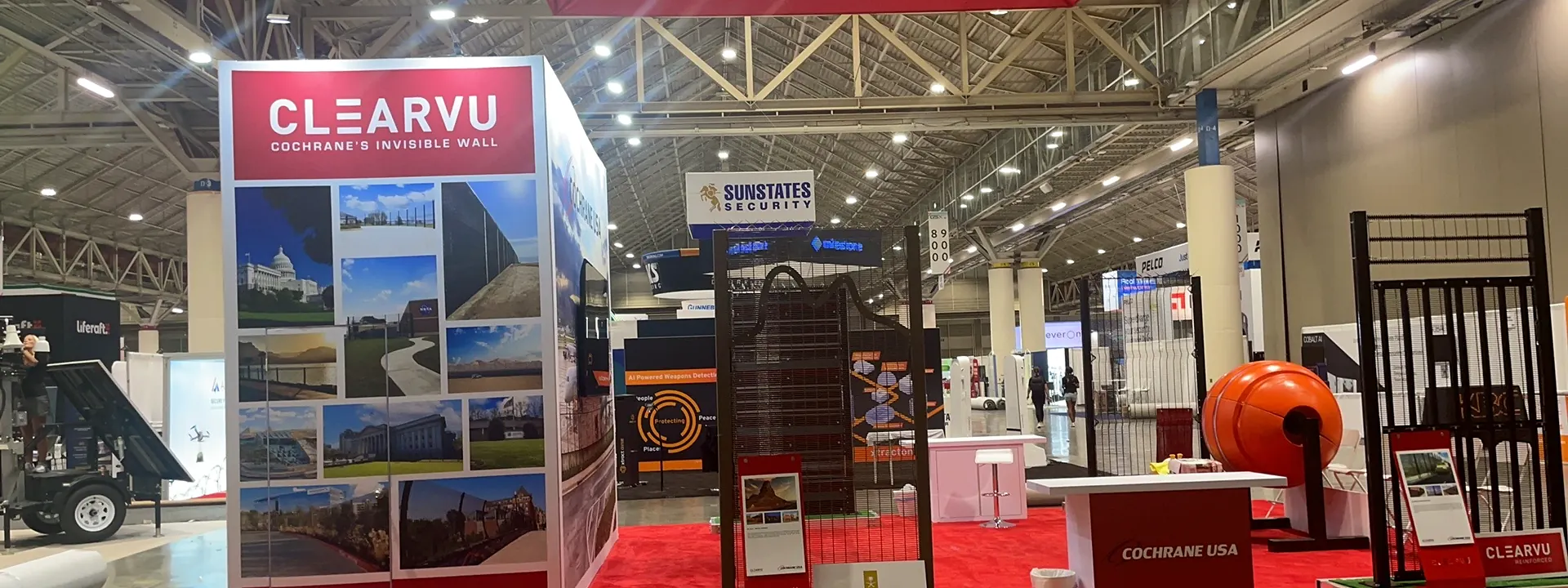 Cochrane USA security barrier exhibit with red carpet and full-height product panels