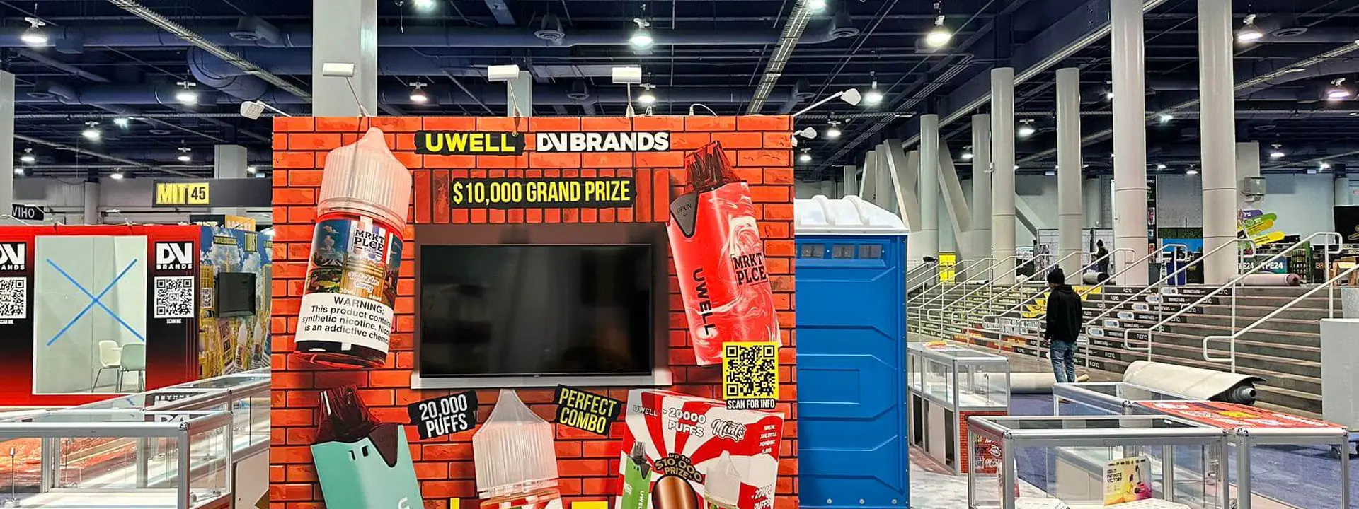 Completed TWIST exhibit with colorful product graphics, glass display cases, a large monitor, and open aisle frontage.