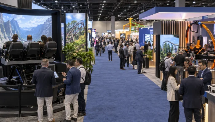 Attractions industry trade show floor with exhibitors presenting ride equipment and interactive technology to professional buyers