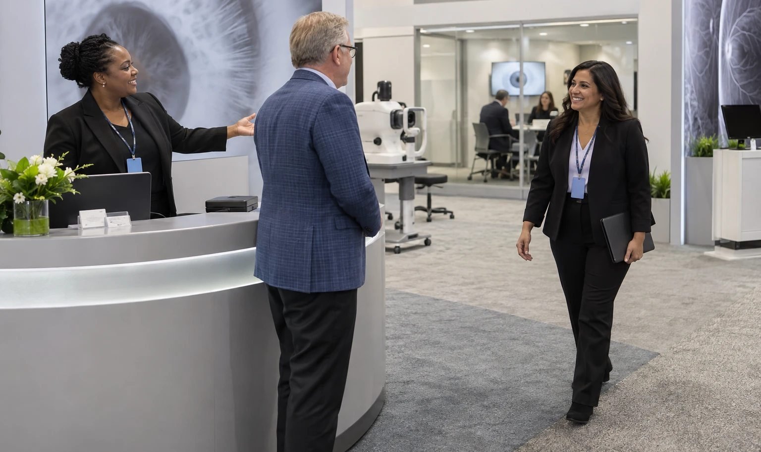Receptionist introducing an ophthalmology exhibit visitor to a clinical specialist in an open booth