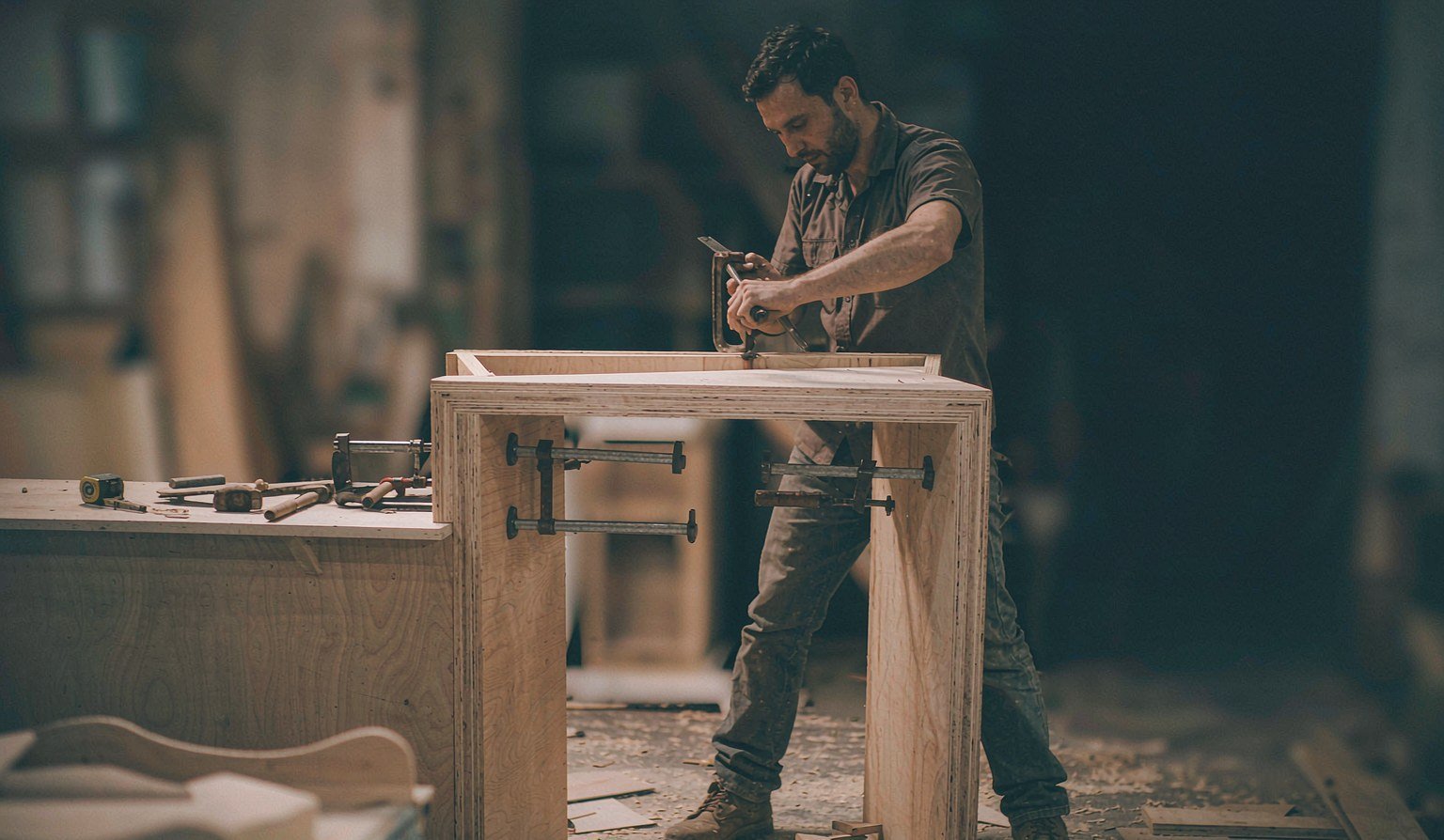 Carpenter assembling a custom reception counter frame in the workshop - Trade Show Rental Furniture
