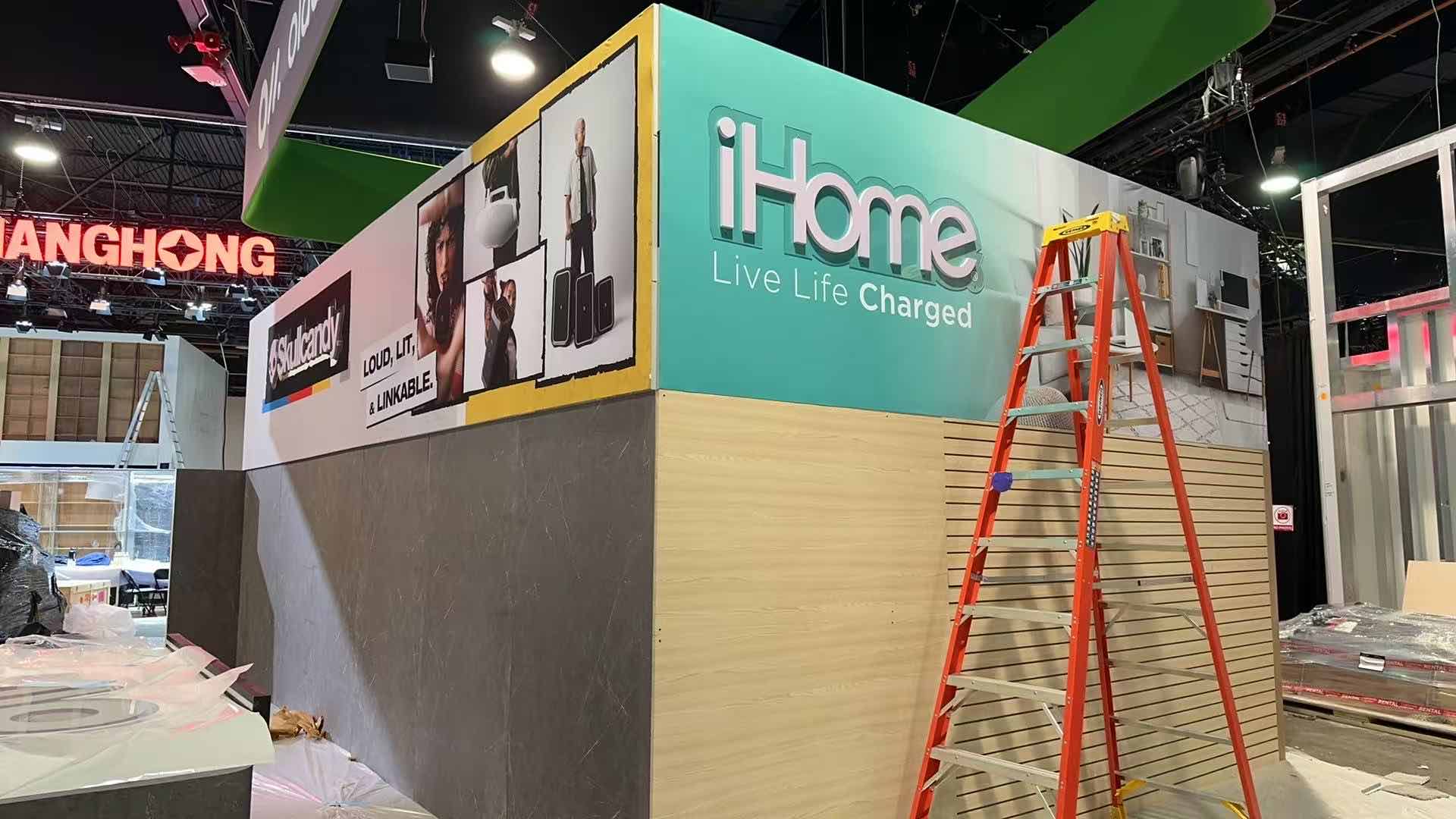 Trade show booth installation in progress with wall structures and ladders