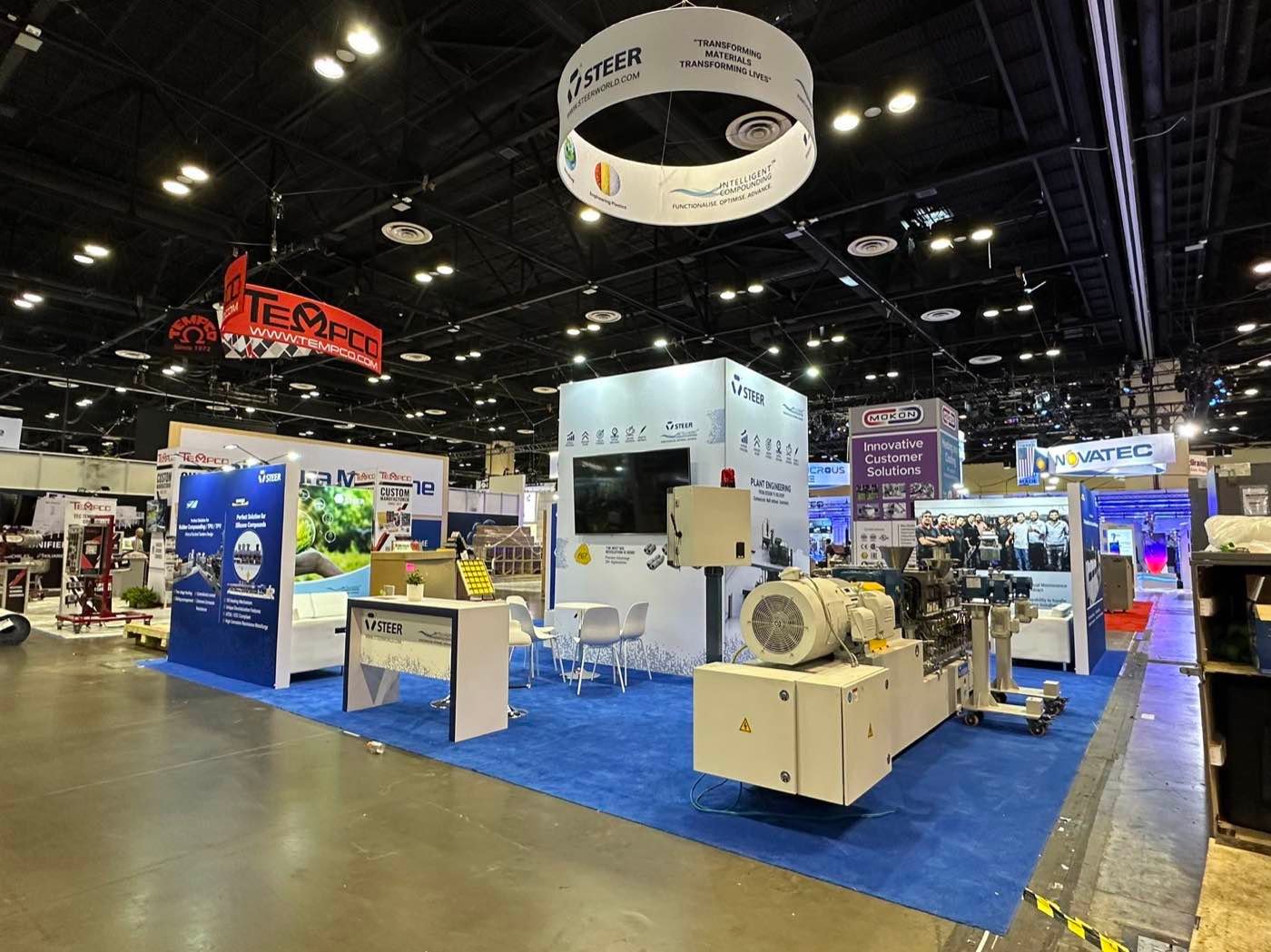 STEER exhibit with large industrial equipment positioned at the front of the booth