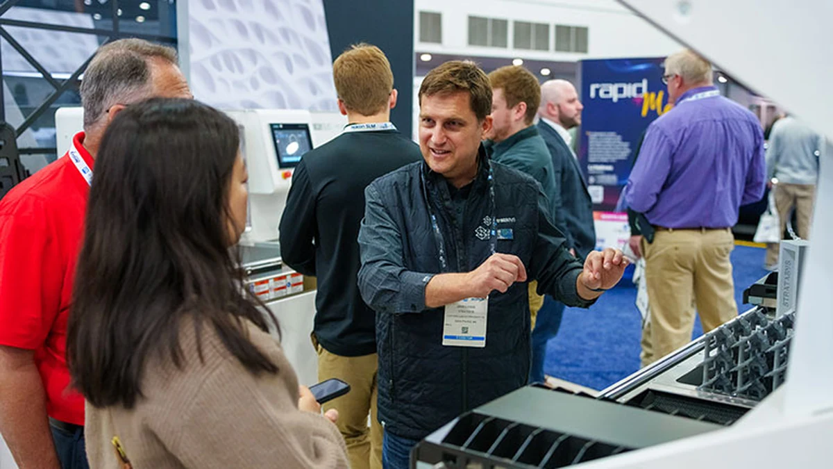 An exhibitor demonstrating additive manufacturing equipment at a previous RAPID + TCT.