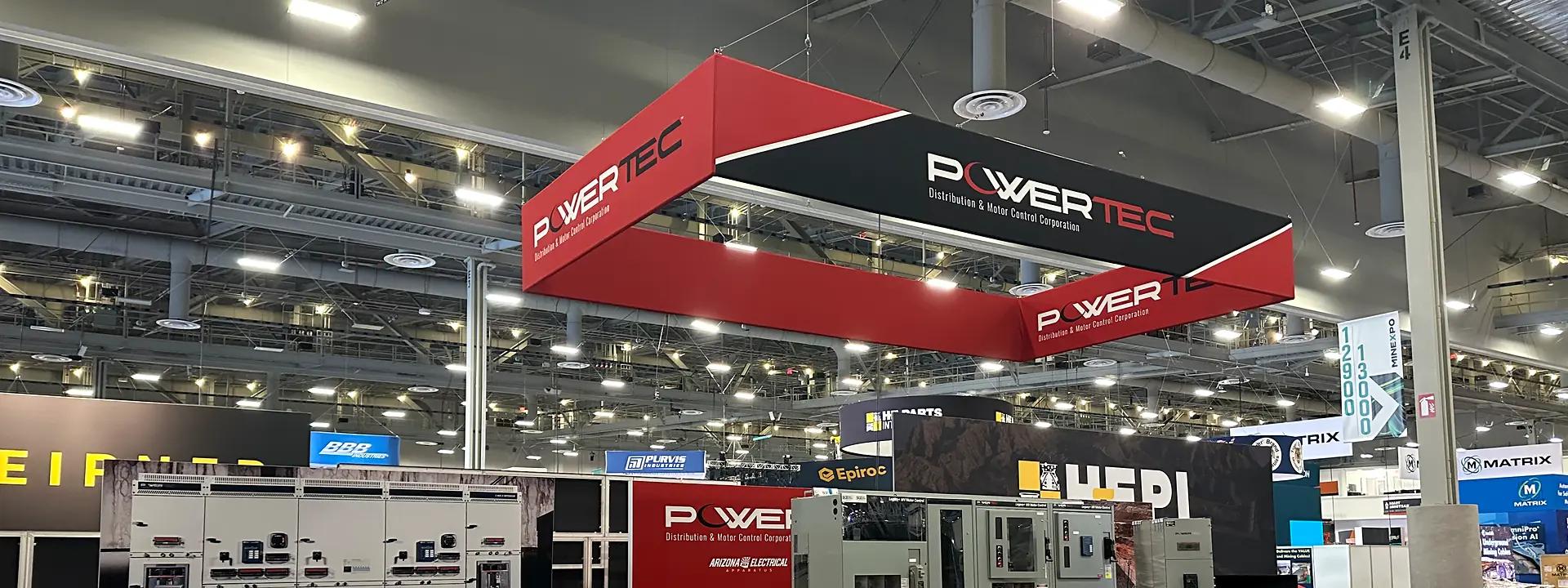 PowerTec industrial equipment booth with red overhead signage and product displays