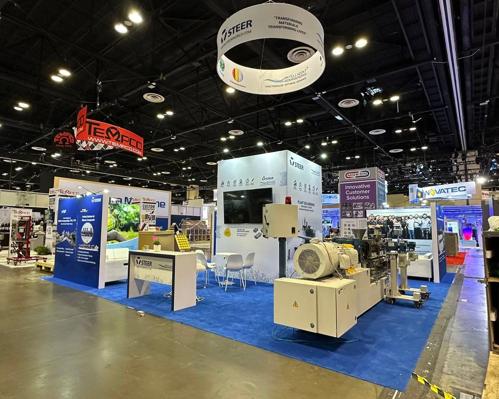 STEER 30 by 30 foot exhibit at NPE 2024 in Orlando, with processing equipment and a blue display area
