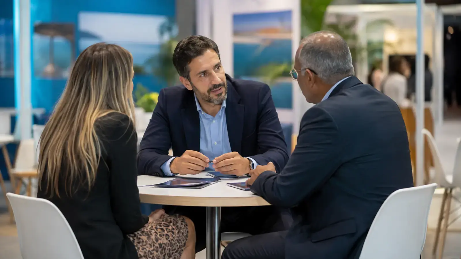 Travel supplier discussing a partnership with professional buyers at an expo meeting table.